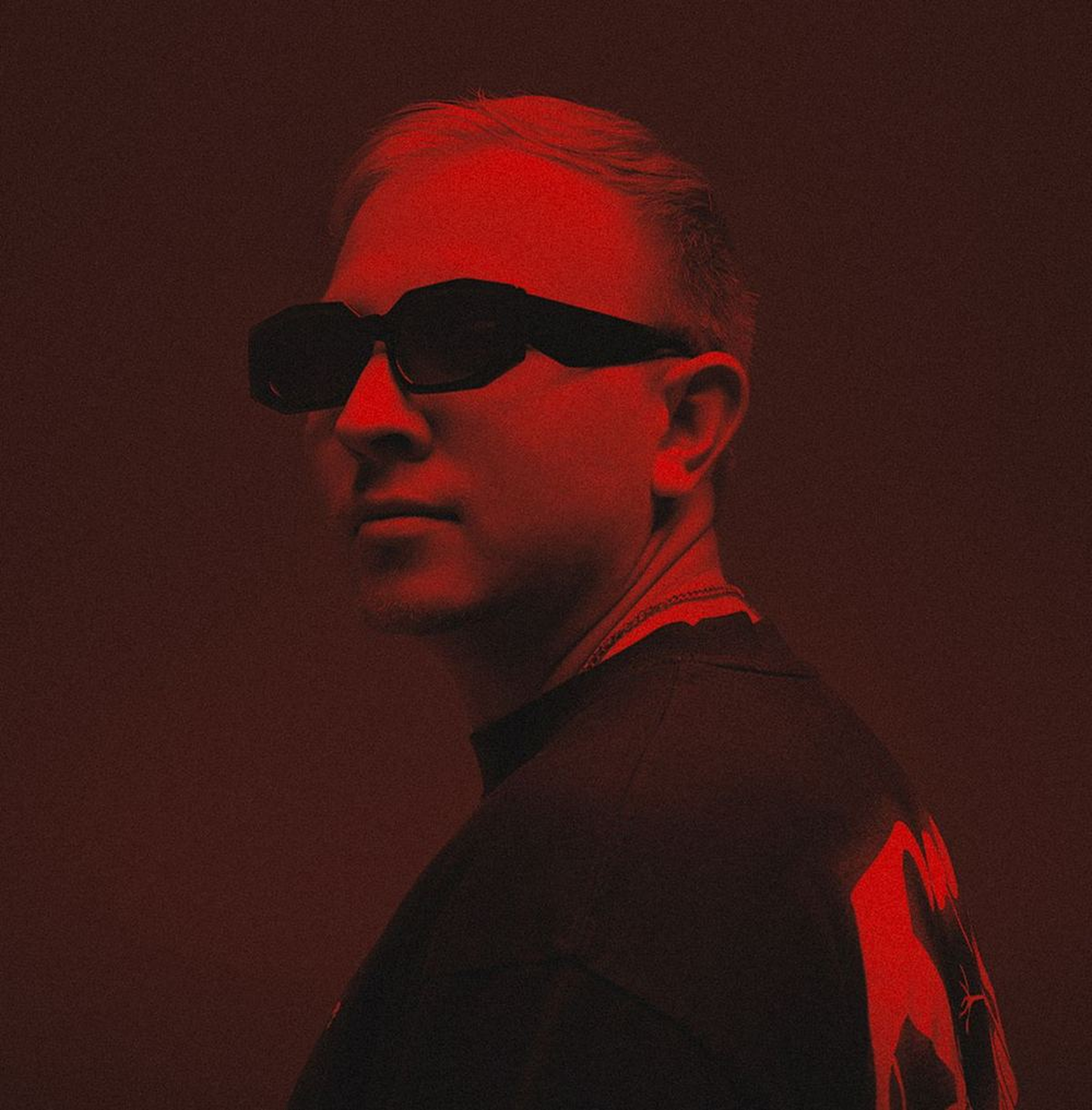High-contrast red portrait, DJ in sunglasses
